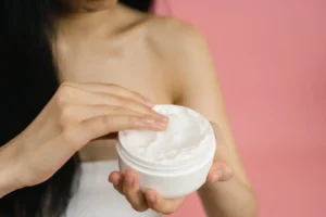 mulher com hidratante corporal