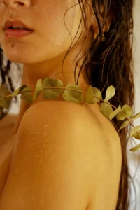 um close up de uma mulher usando um colar com folhas sobre ele