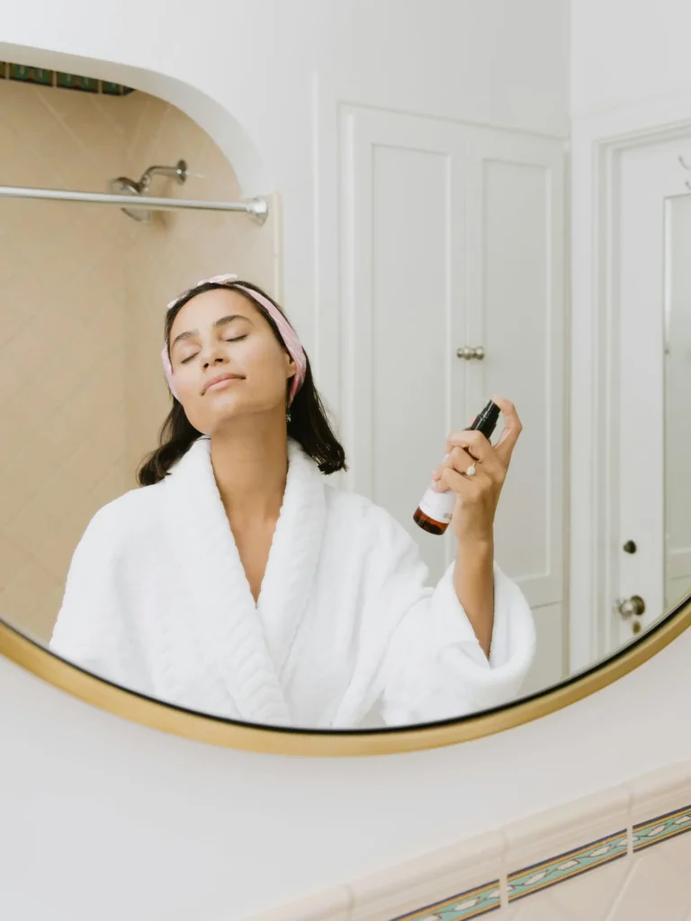 Mulher de roupão branco em um ambiente de bem-estar, associado a skincare e saúde da pele