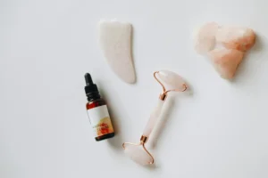 Garrafa de plástico branca e preta ao lado de ornamento em forma de coração, representando produtos usados em uma rotina de skincare e cuidados com a pele.